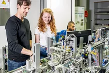 Zwei Personen vor einer großen elektrischen Anlage
